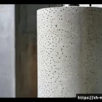 고강도 콘크리트 특징 - Photorealistic close-up of a high-strength concrete cylinder undergoing a compression test in a mode...